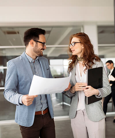 Ventajas para empresas - Hombre y mujer de negocios hablando en una reunión en la oficina Ventajas para empresas - Hombre y mujer de negocios hablando en una reunión en la oficina