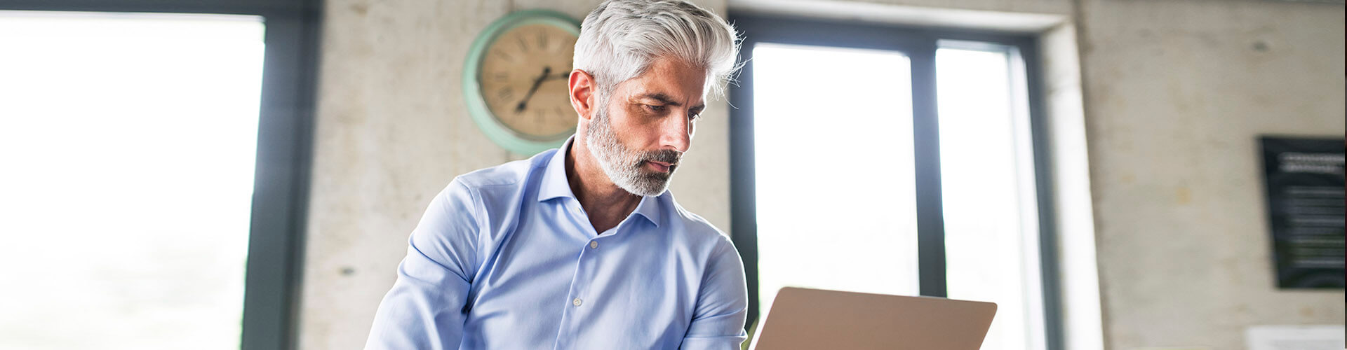 Servicio de Valores Online - Hombre de negocios sentado con su portatil en la oficina