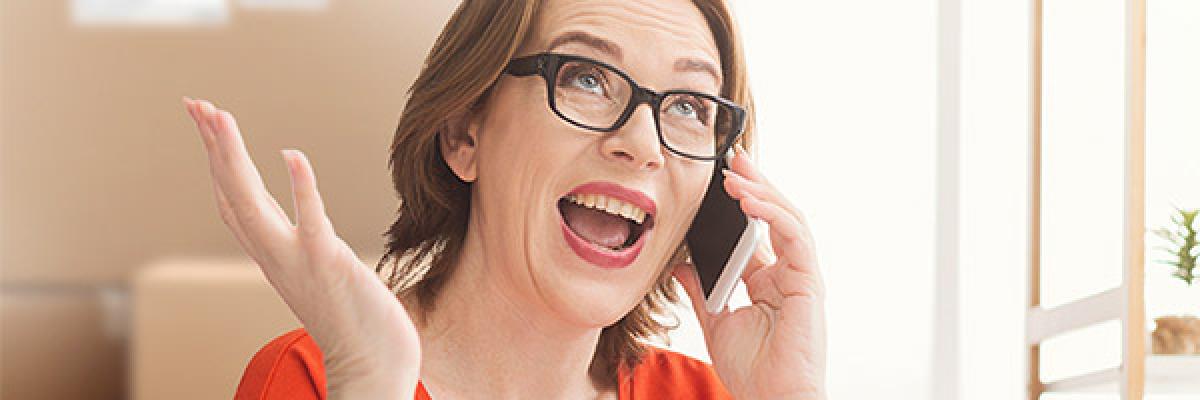 Programa Porque Somos Así Autónomos - Mujer de mediana edad autónomos gafas y camisa roja hablando por teléfono móvil desde su negocio Programa Porque Somos Así Autónomos - Mujer de mediana edad autónomos gafas y camisa roja hablando por teléfono móvil desde su negocio